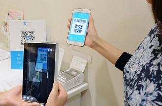 アプリをスマホで表示し、店の専用端末で読み取ると支払い完了（写真：共同通信社）