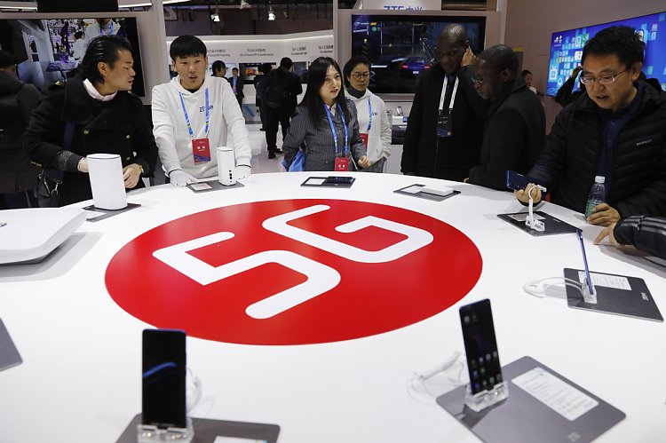 北京で開催された「世界5G大会」で対応スマホを見る来訪者たち（EPA＝時事）