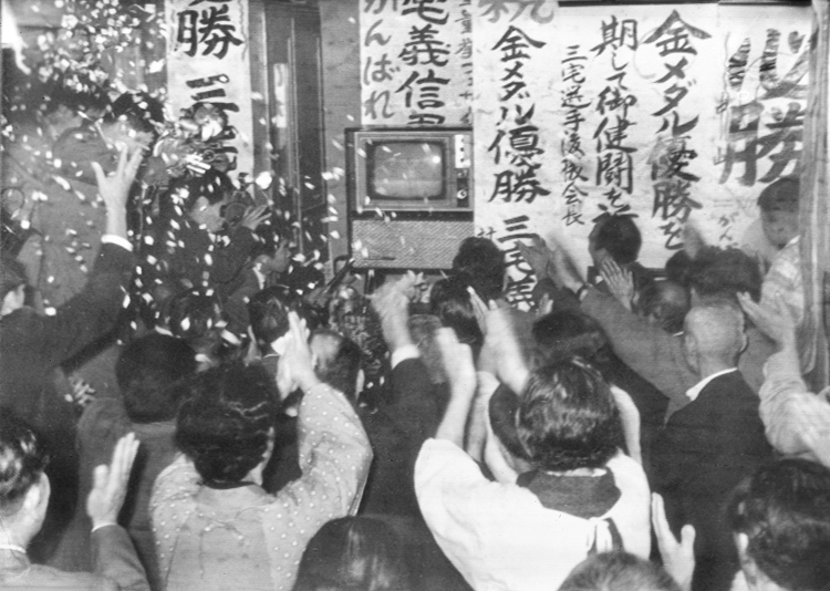 1964年当時、テレビで東京五輪を観戦する人々（写真：共同通信社）