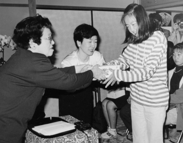 山崎豊子さんが作中に忍ばせた「遺言書」とは（「山崎豊子文化財団」の奨学生第1期生に奨学金と著書を手渡す山崎さん（写真左）と野上孝子さん（写真中央））（1994年）