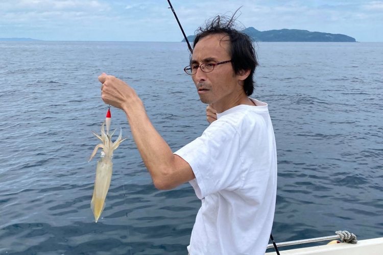 唐津の海でイカ釣りを楽しむ筆者。顔は険しいけど楽しんでいます