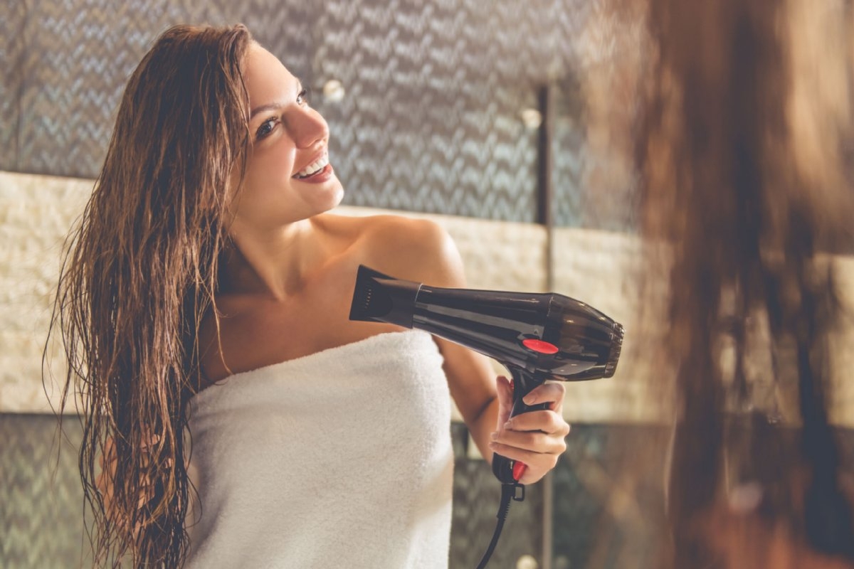 お風呂上がりにドライヤーでヘアケアするのは女性のたしなみ（写真：アフロ）