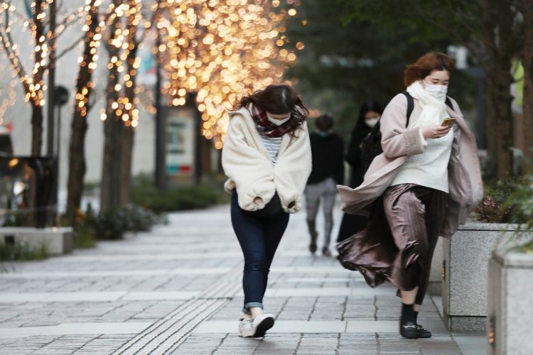 「春一番」が吹いた昨年2月4日、強風のなか東京・都心を歩く人たち（写真／時事通信社）