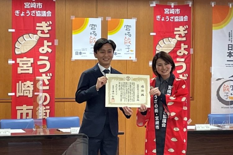 宮崎市の清山知憲市長（左）から感謝状を受け取る宮崎市ぎょうざ協議会の渡辺愛香会長（写真／宮崎市ぎょうざ協議会提供）