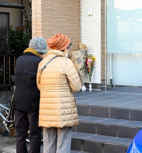 殺害された鈴木さんのクリニック前には、手を合わせる人々の姿が。地域の人たちから慕われた在宅専門医だった（時事通信フォト）