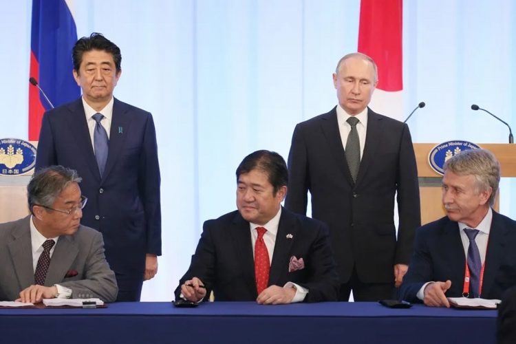 他の事業にも影響が出かねない（2019年、安倍晋三元首相、プーチン大統領同席のもとで「アークティック2プロジェクトに係る株式売買契約書」に署名する三井物産の安永竜夫社長＝当時。時事通信フォト）