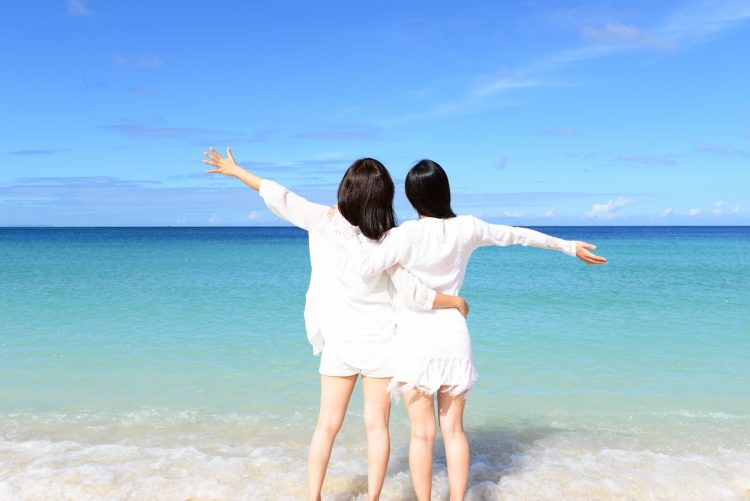 沖縄の綺麗な海辺でくつろぐ女性たち（イメージ）