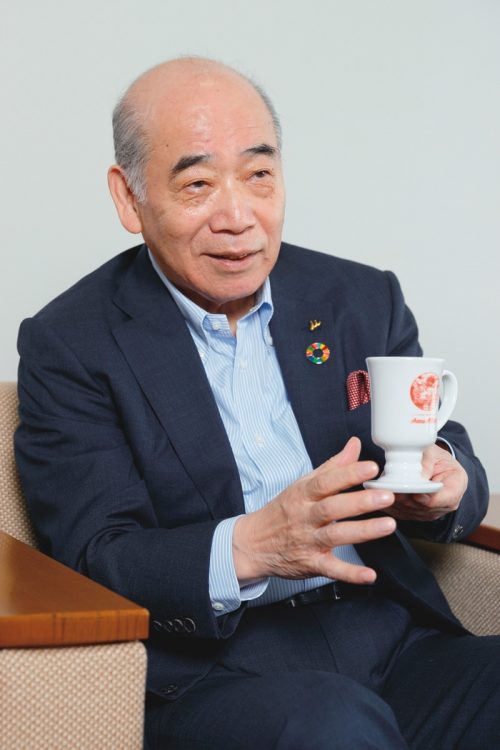 アンミラ名物のコーヒーカップを片手に話す浅田会長