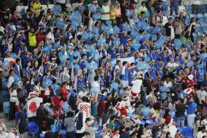 ブルーのゴミ袋を膨らませて日本代表に声援を送る大勢のサポーターたち（12月5日。時事通信フォト）