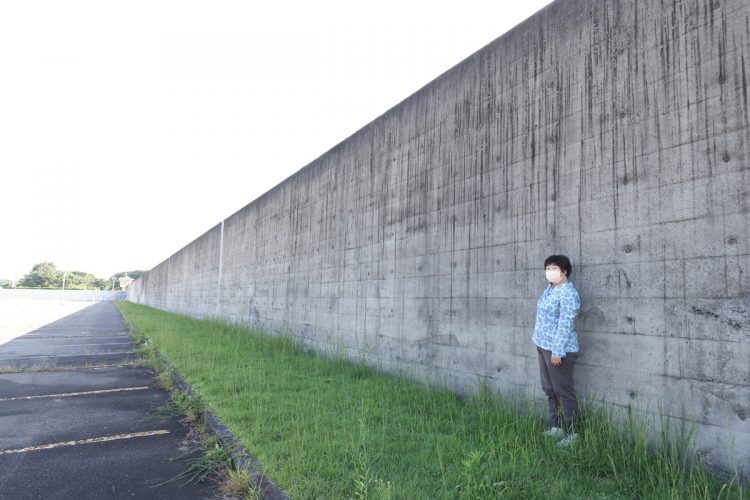 旧黒羽刑務所をぐるりと取り囲む塀。身長165㎝のオバ記者と比べて、この高さ。逃げようとは到底思わない