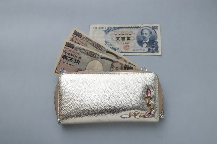 ゴールドの外見と宝石状の飾りに一目惚れして買った文子ママの長財布。五百円札はお客さんからもらったものだ