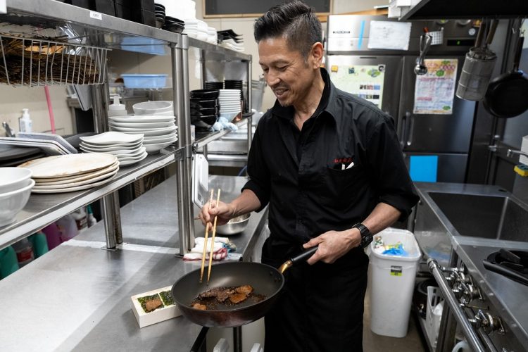 焼肉弁当をつくる朝長さん（撮影／比田勝大直）