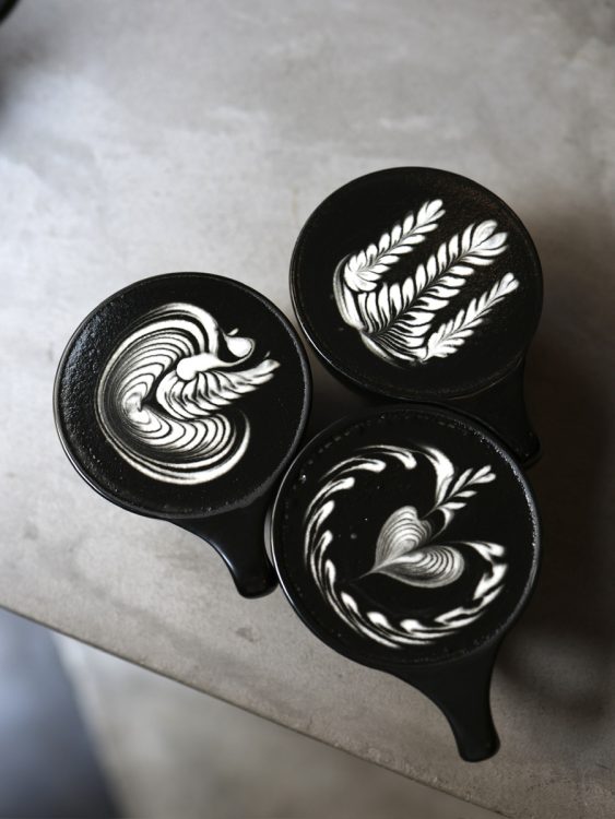黒×白のコントラストが美しいブラックラテ。左がスワン柄。リーフやハートなどを組み合わせて、オリジナルの模様を描く
