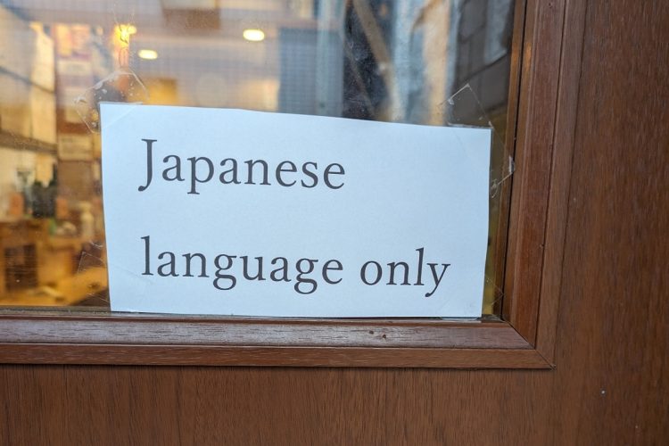 「Japanese language only（日本語対応のみ）」の張り紙を店頭に掲出している