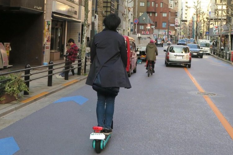 車道をノーヘルで走行する電動キックボード（疋田智氏提供）