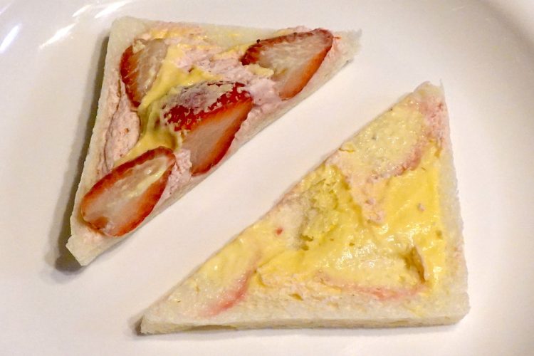 ローソン『苺＆ダブルクリームサンド』のパンを開いた様子。断面側に半分のいちごが1個と4分の1位のいちごが2個、奥に4分の1のいちごが1個入っていた