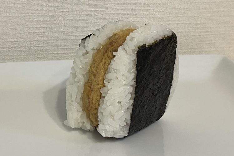 セブン−イレブン『具だくさんおむすび　かつ丼』。玉子でとじたとんかつをごはんで挟んだスタイル