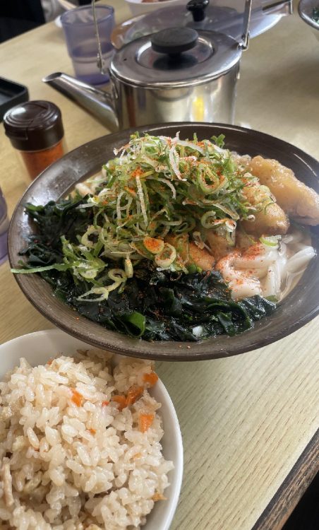 「牧のうどん」でごぼう天わかめうどんにネギと一味を大量に乗せ、かしわご飯をつけたもの