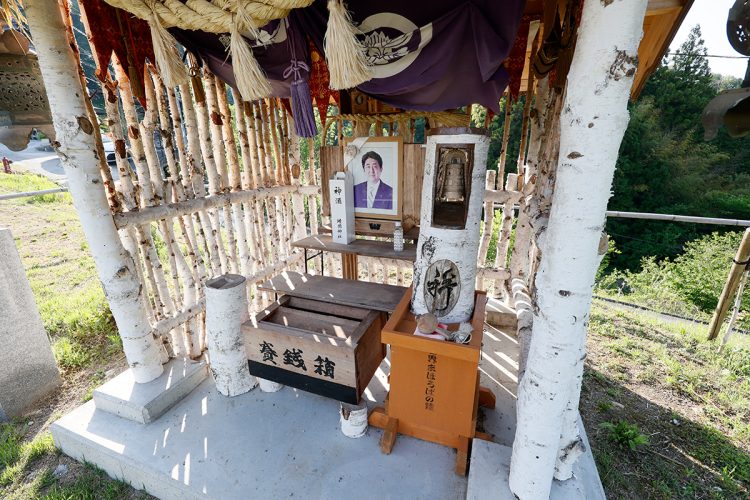 安倍氏の写真の前に小さな賽銭箱が置かれている
