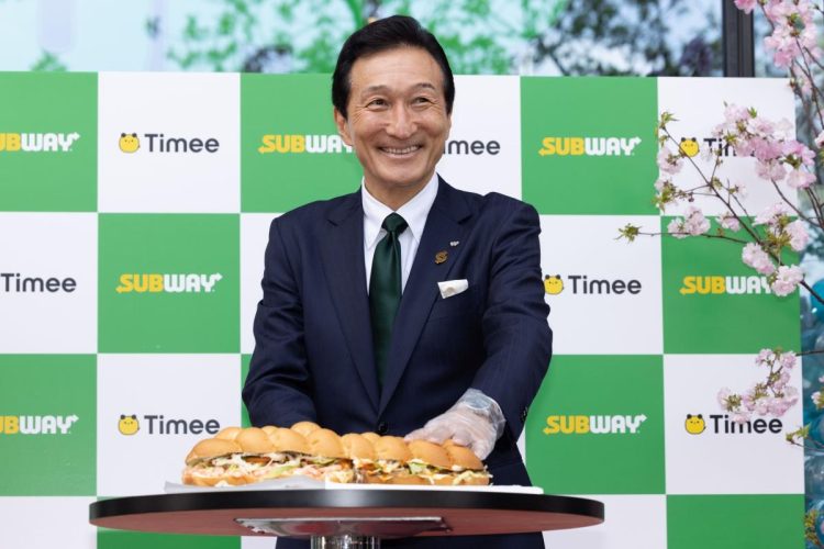 開店セレモニーで、巨大サンドイッチにナイフを入れる渡邉会長