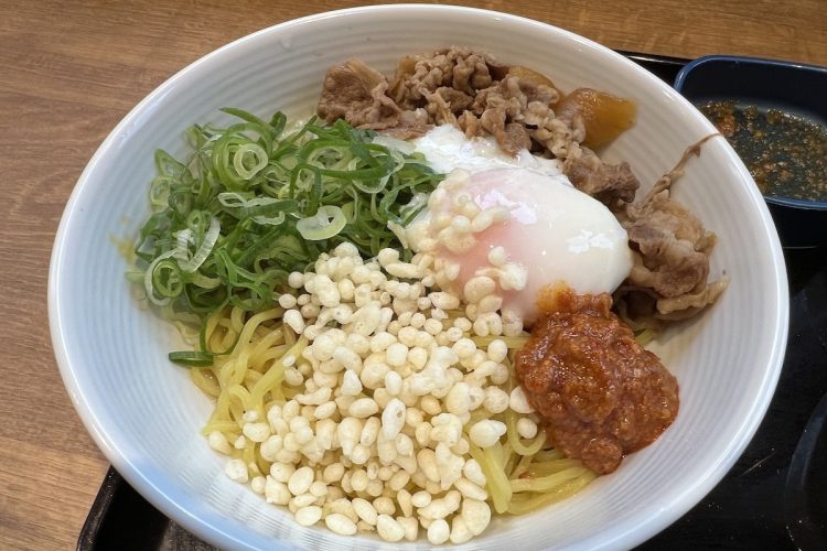 『牛玉スタミナまぜそば』に半熟玉子とにんにくマシマシだれを乗せて、彩りも豊かに