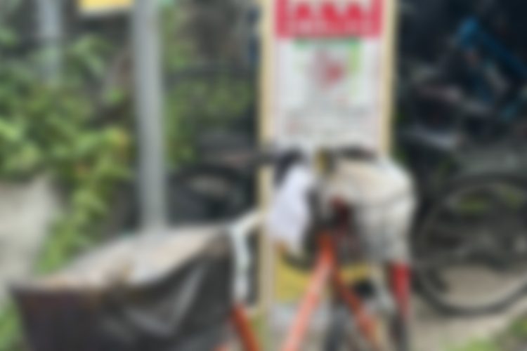 自転車のかごにビニール袋が詰まった違法駐輪状態の自転車
