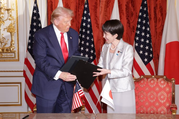 署名した文書を交換するトランプ大統領(左)と高市早苗首相(時事通信フォト)