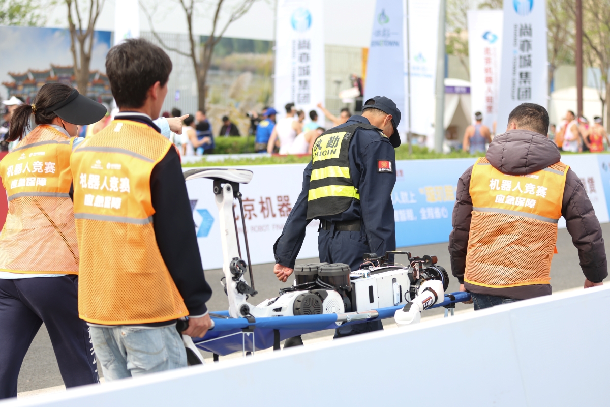 途中で倒れて担架に乗せられて運ばれる人型ロボットもあった（Getty Images）