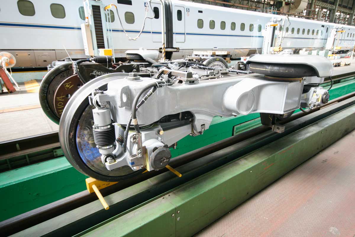 新幹線の電車(奥)と、その台車(手前)。横から見ると、モーターが見えない。JR西日本博多総合車両所一般公開イベントにて筆者撮影