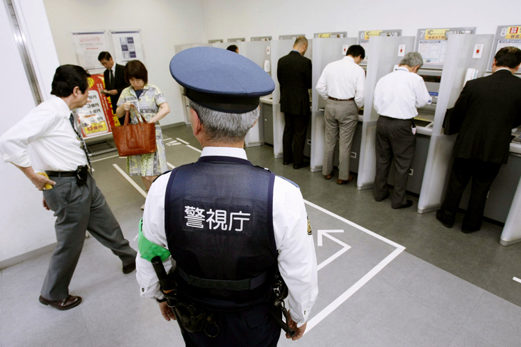 銀行のATMの前に警官の姿も…（写真：共同通信社）