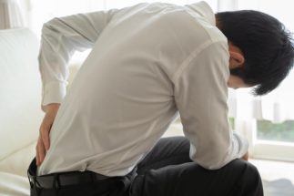 慢性腰痛などの「原因不明の痛み」もパーキンソン病の重要サインのひとつ（イメージ）